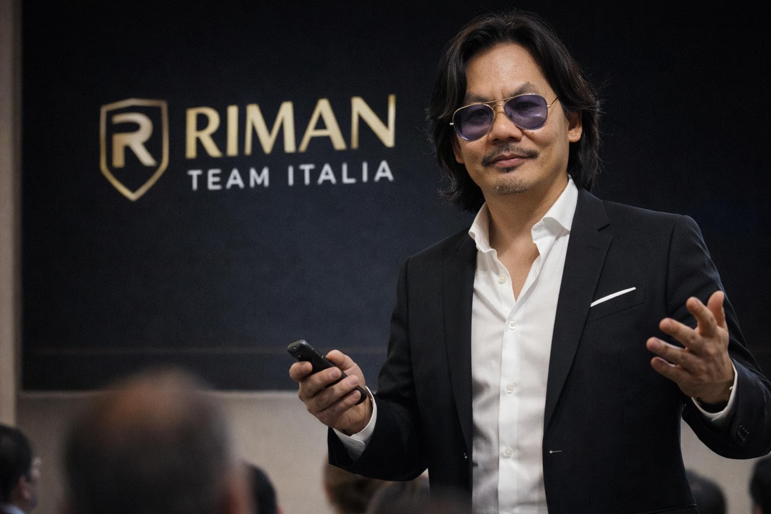 Dien To bei einer Präsentation vor dem RIMAN Team Italia Hintergrund.